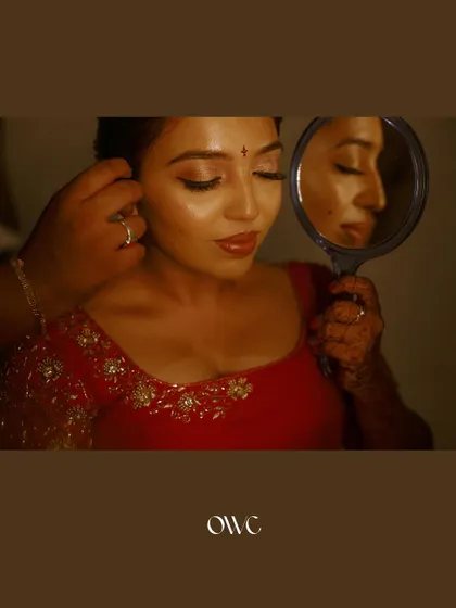 A creative bridal portrait with the bride looking into a hand mirror, capturing a moment of reflection.