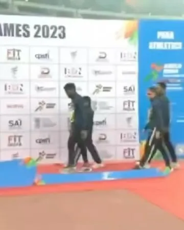Para-athlete Jyothi and her guide runner Vikram walking to the podium to collect their bronze medals at the Khelo India Para Games.