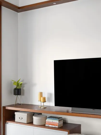 A detail shot of the family space in our 'Gulmohar' project, showing the clean lines of the TV unit and the warm wooden ledge that runs across the wall.