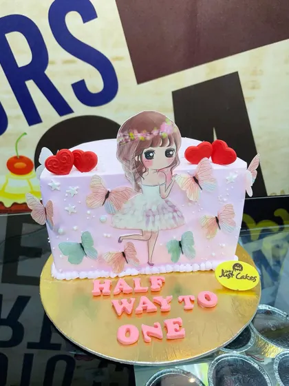 A charming 1kg "Half Way to One" cake with a cute anime-style girl and butterfly decorations.