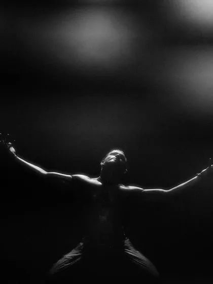 A black and white image of me in a powerful pose from 'Naga Mandala', with arms outstretched towards the heavens.