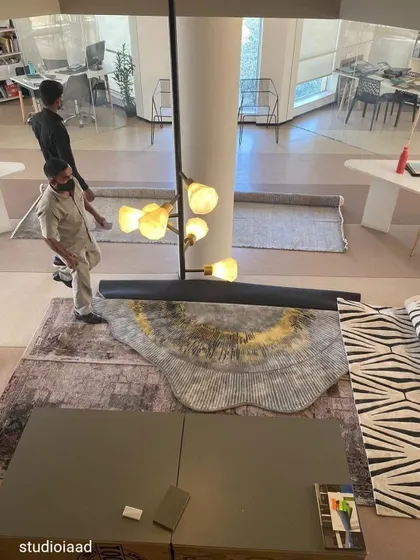 Material sourcing is a crucial part of our ideation process. This image from our studio shows the unrolling of carpet samples, a hands-on step where we amalgamate different materials, colors, and textures to find the perfect combination for a project.