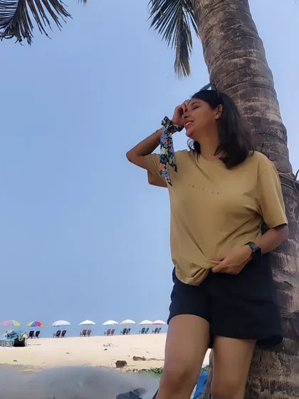 A casual beach day look with a simple knotted t-shirt and black shorts. The printed scrunchie on my wrist adds a small, fun detail.