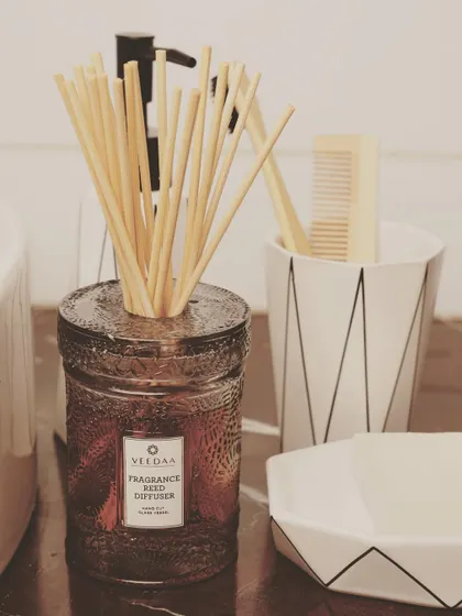 Our Persian Oud reed diffuser, set up and ready to fragrance a modern, monochromatic bathroom. The dark glass and rich scent add a layer of deep sophistication.
