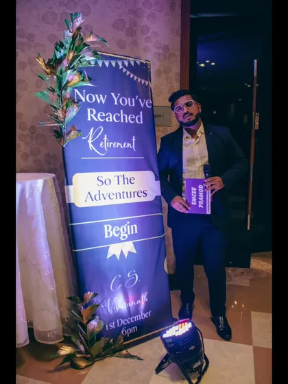 Posing next to a retirement banner. I take pride in celebrating life's major milestones with my clients.