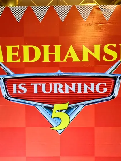 The custom backdrop for a Cars themed 5th birthday, announcing 'Medhansh is turning 5'.