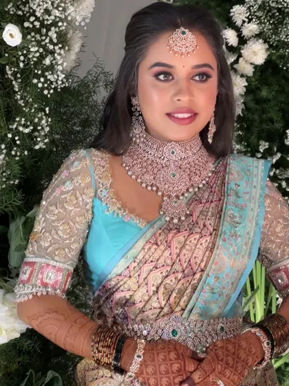 This client looks absolutely stunning in a pastel blue and pink saree. I designed a matching blue blouse with intricate silver embroidery, creating a look that is both modern and elegant for her reception.