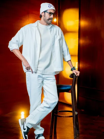 Rana Daggubati in a layered, all-white look. The open shirt over a tee, paired with white jeans and a beanie, creates a cool, tonal outfit that’s perfect for a casual event.