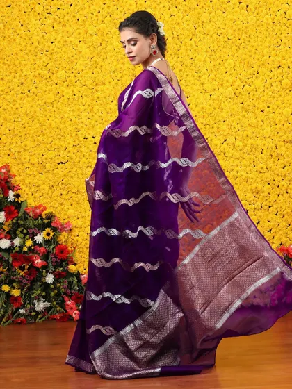 A unique purple organza saree with silver metallic wave patterns, a modern take on traditional weaving.
