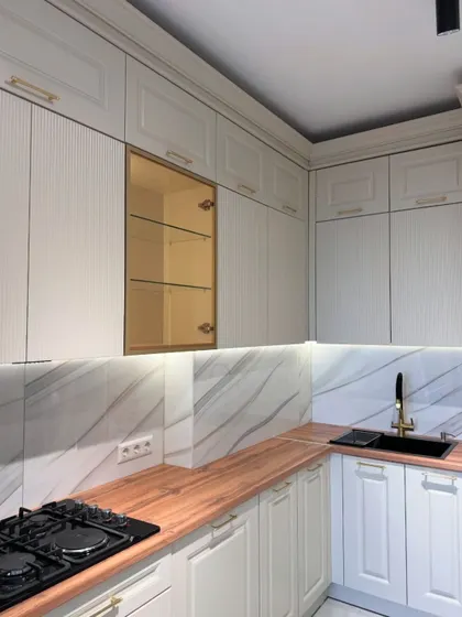 This angle shows the other side of the L-shaped classic kitchen, featuring a modern black sink and faucet that contrasts beautifully with the traditional cabinetry.