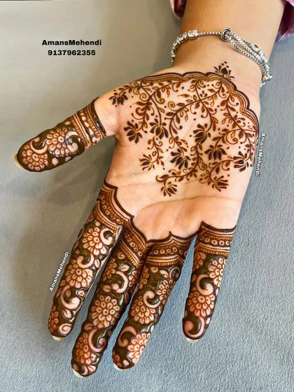 A simple yet stunning palm design. The focus is on the intricate floral pattern that fills the fingers, leaving the center of the palm open.