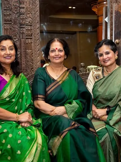 Co-founder Gayathri Shetty with guests at the book launch, seated before a backdrop of intricately carved wooden panels, typical of the heritage homes we documented.