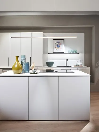 A crisp white kitchen from our Novelties 2025 collection. The minimalist island and handleless cabinets create a clean, modern aesthetic, perfect for any contemporary home.