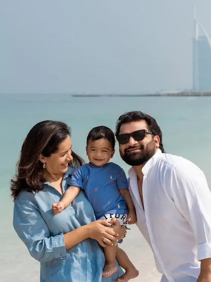 A happy family enjoying a day at the beach in Dubai, with the iconic Burj Al Arab in the background. This photo is also a great example of how editing can enhance a beautiful moment.