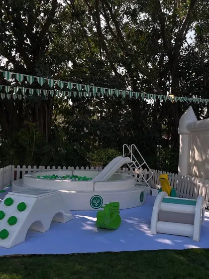 A dedicated soft play area for the youngest guests at the Tennis Club party. This safe and fun zone included a ball pit, a small slide, and ride-on toys, all in a clean white and green colour scheme.