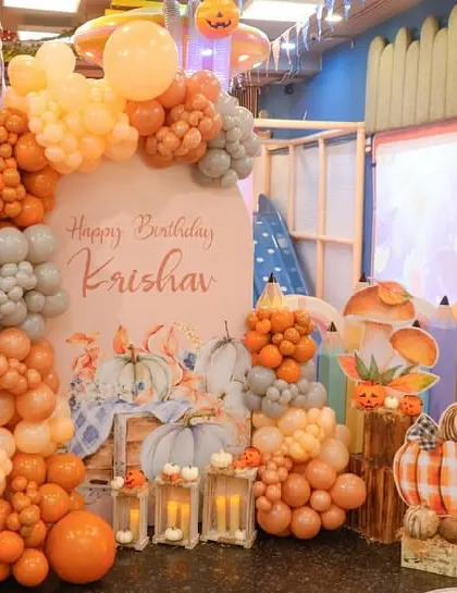 A spooky and fun pumpkin-themed birthday setup for a 5-year-old. We used shades of orange, grey, and white balloons along with pumpkin cutouts to create a festive autumn atmosphere.