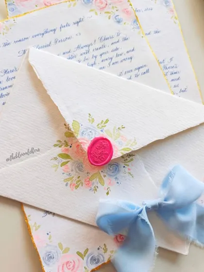 A handwritten letter and matching envelope, both adorned with vintage pastel roses. This showcases how I carry a cohesive design across different stationery elements.