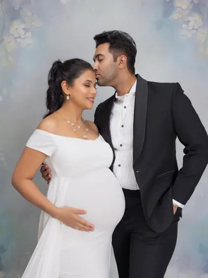 A tender forehead kiss, a classic expression of love. This pose is a beautiful way to capture the affection and bond between a couple during their maternity photoshoot.