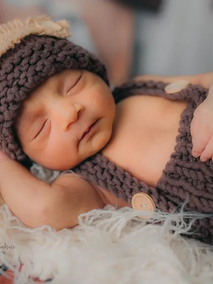 This close-up shows the delicate details of the baby's face and hands. These are the tiny features you'll want to remember forever from a newborn lifestyle photoshoot.