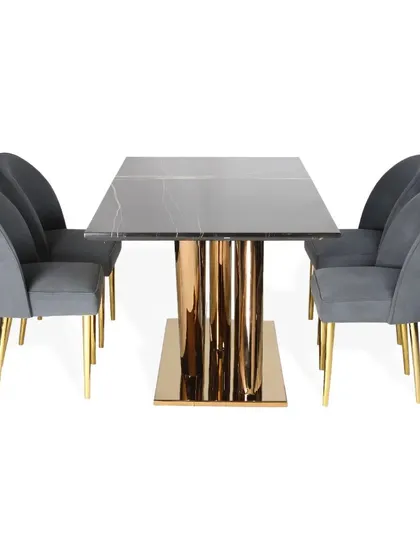 A bold dining set featuring a black marble top on an asymmetrical pedestal with a glossy PVD gold finish. The accompanying chairs are upholstered in a complementary grey fabric, creating a balanced and dramatic look.