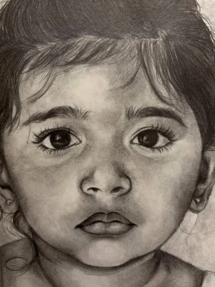 An extreme close-up on the eyes of the baby portrait. This is where the soul of the sketch lies, and I spend a lot of time making sure they reflect the child's true spirit.