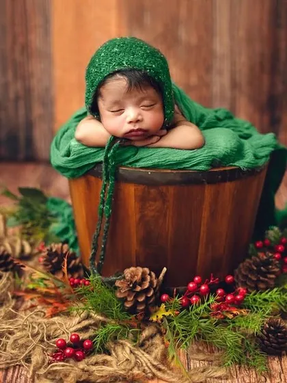 A slightly different angle of this peaceful pose, surrounded by festive holly and pinecones. This setup is perfect for babies born around the holiday season.