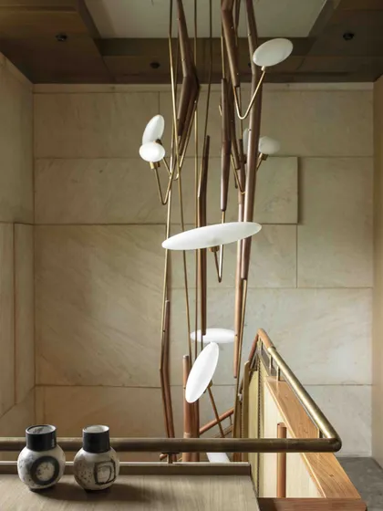 Looking down the meticulously detailed staircase, the sculptural form of the Klove Grasshopper light is fully appreciated. It is a functional element transformed into a central art piece.