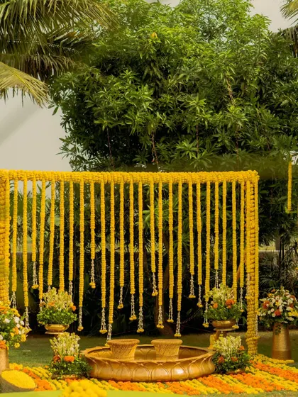 This minimalist haldi setup was designed to feel warm and inviting, just like home. The backdrop of marigold strings and traditional urlis creates a sacred and beautiful space for the ceremony.