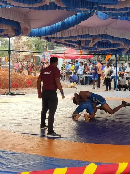 A wrestler executes a takedown during a mat-based competition.