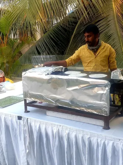 Here is another view of my live dosa station in action at an outdoor event. We ensure every item is cooked fresh on-site, providing an authentic taste experience.