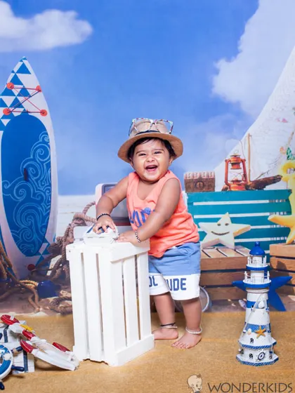A joyful baby boy having a blast in our beach-themed studio setup. The bright colors and fun props create a lively and cheerful atmosphere for his photoshoot.