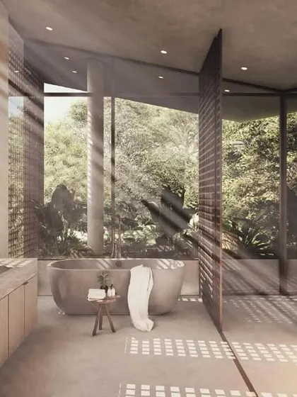 This bathroom in the House of Veils is a study in filtered light and texture. Perforated screens create a dramatic play of sun and shadow, while the open layout connects the bathing and dressing areas to the lush green outdoors.