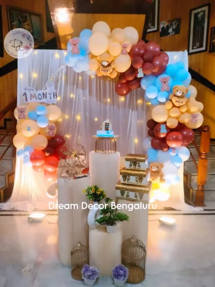 A full setup for a one-month celebration. We use elegant plinths, props like vintage suitcases, and a beautiful balloon arch to make even the smallest milestones feel grand.