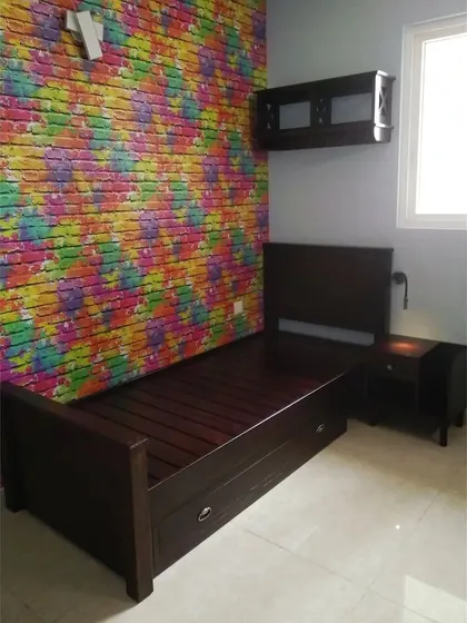 This single bed with under-bed storage is perfect for a teen's room, paired with a colorful brick-patterned wallpaper for a fun, urban vibe.