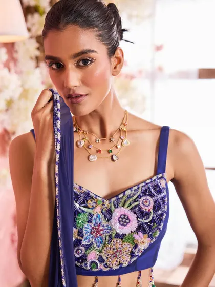 A beauty close-up from the festive campaign, highlighting the detailed floral embroidery on the blouse. The makeup is soft and luminous, with a focus on flawless skin and a subtle shimmer.