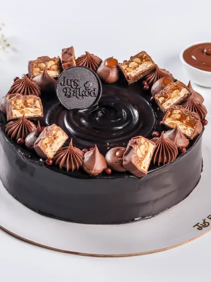 This rich chocolate cake is topped with chunks of Snickers, caramel, and chocolate swirls. It's a decadent treat that satisfies any chocolate and caramel craving.