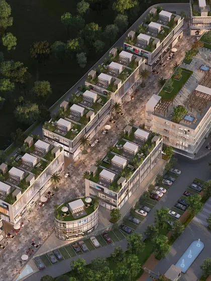 An aerial view of a commercial high-street development at dusk. This perspective shows the layout of the retail buildings, pedestrian zones, and the flow of evening activity.