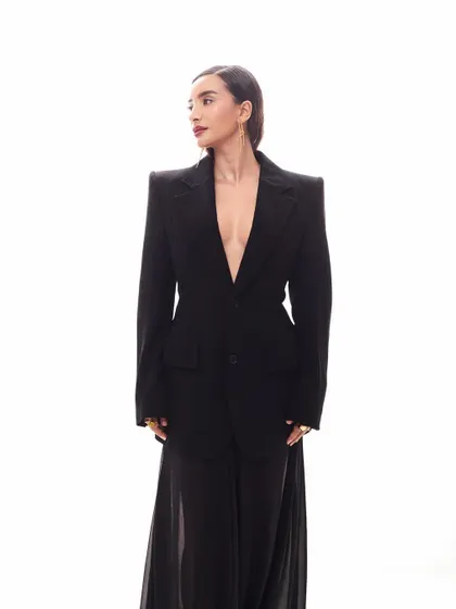 This angle shows the beautiful contrast between the sharp, opaque blazer and the soft, flowing sheer skirt. It's a look of beautiful contradictions.