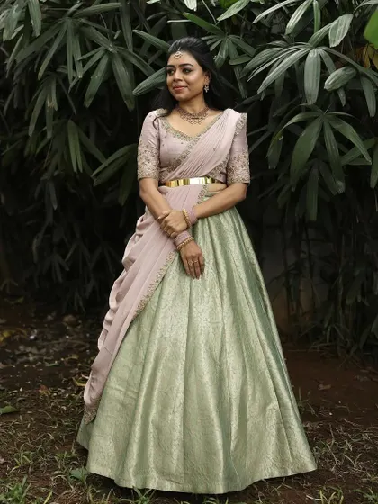Dr. Tushara in a beautiful pastel green and pink lehenga. This Indo-Western style with a pre-draped dupatta is perfect for an elegant, modern look.