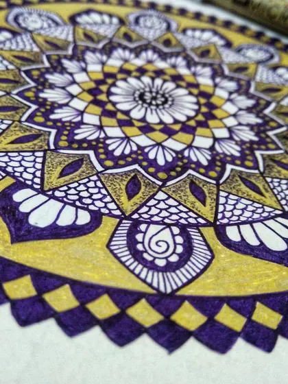 A close-up, angled shot of the violet and gold mandala. This perspective highlights the texture of the paper and the precise ink work of the Micron and Uniball pens.