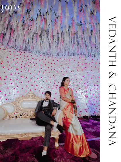 An elegant portrait of a couple seated on a vintage couch against a stunning, floor-to-ceiling backdrop of white and pink flowers. This shot demonstrates my eye for composition and ability to capture the grandeur of a beautifully styled wedding reception.