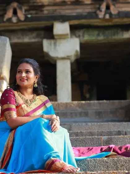 A beautiful sky blue saree with a traditional temple border, paired with a contrasting maroon blouse for a classic look.