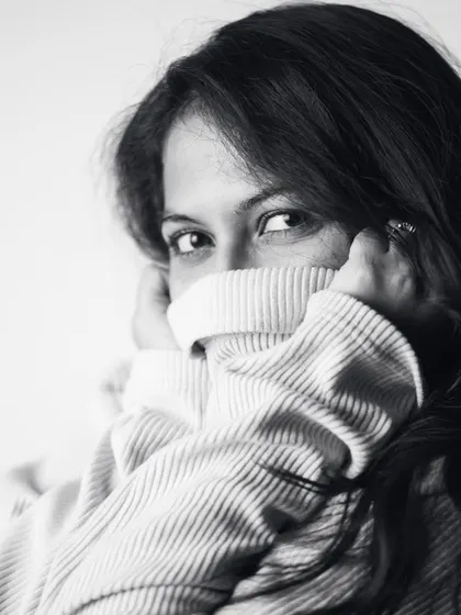 A playful and cozy shot using a turtleneck sweater to frame my face. This image adds a touch of shyness and warmth to the boudoir collection.