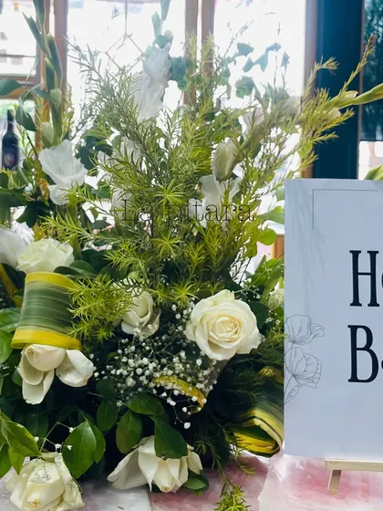 A simple 'Hello Baby' sign next to a fresh floral arrangement, a sweet and welcoming touch.
