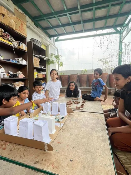 A facilitator listens as a young champion presents their group's model for a sustainable Jayanagar Shopping Complex. We empower children to think critically about their communities.