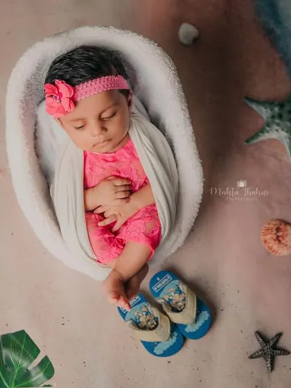Even a beach babe needs her beauty sleep. This little one is peacefully napping, wrapped snugly for her beach-themed photoshoot.