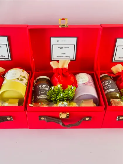 These red suitcase hampers were customized for "Mossimo Clothing," featuring their logo and a "Happy Diwali" message on a card inside.