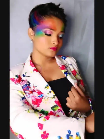 A Holi-inspired creative makeup look, using a rainbow of colors across the forehead and hair to celebrate the festival of colors.