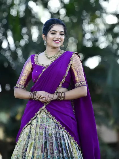 The vibrant purple of the davani and blouse contrasts beautifully with the intricate Paithani skirt.