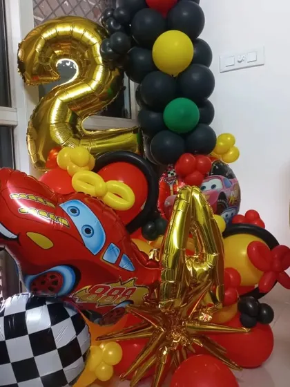 Here is a balloon bouquet for a 2nd birthday based on the Disney movie 'Cars'. It features a large Lightning McQueen foil balloon, a number '2' foil, and a checkered racing flag balloon.